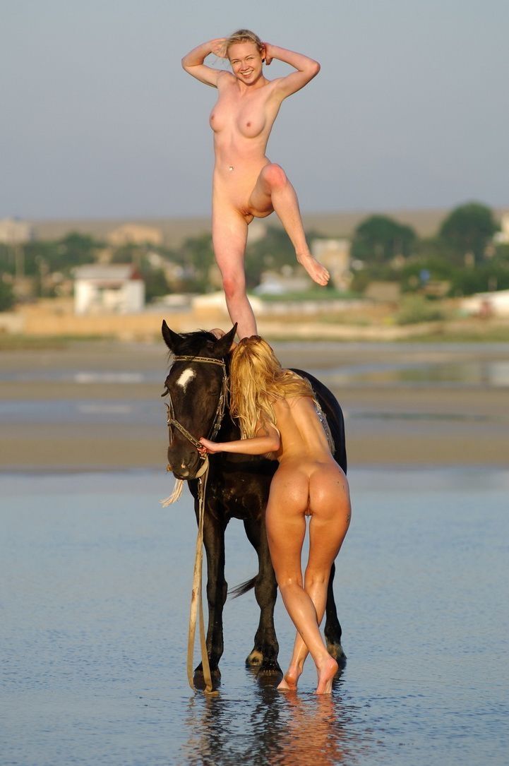 two blonde girls on the beach with a horse