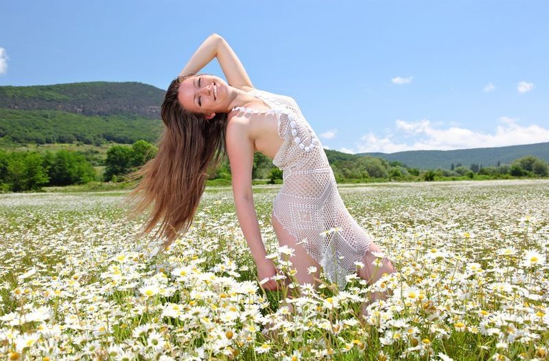 brunette girl on the field of daisy flowers