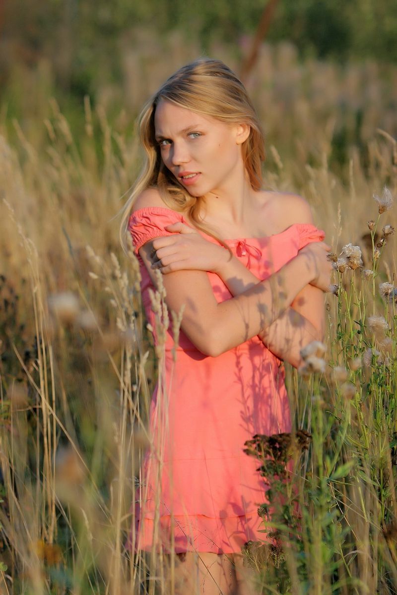 cute young blonde girl outside on a meadow