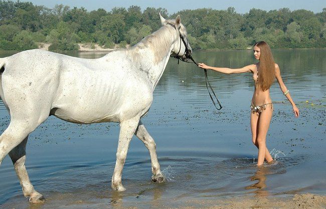 cute young blonde girl posing with a horse