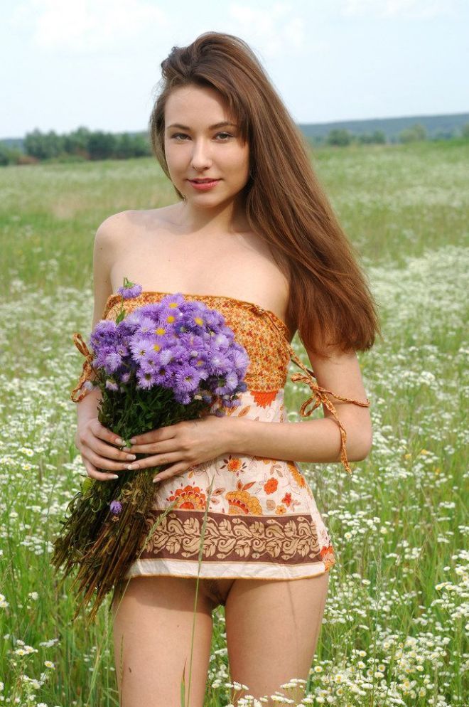 young brunette girl on the field of wild flowers