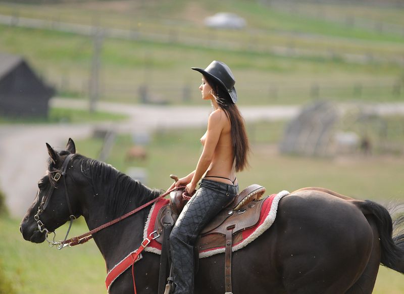 brunette girl shows off her cowboy skills with a horse and colt revolver
