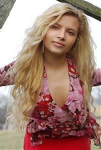 Babes: young curly blonde girl wearing a red dress in the village