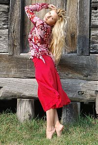 Babes: young curly blonde girl wearing a red dress in the village