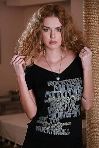 Babes: young curly reddish blonde girl undresses black t-shirt at home