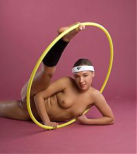 Nake.Me search results: cute young brunette girl with a white headband doing flexible exercises with the gymnastic hoop
