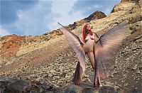 Babes: young red haired girl with butterfly wings on rocky mountains