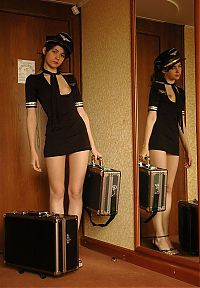 Babes: cute young brunette girl with suitcases reveals in a conductor uniform