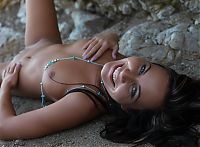 Babes: young brunette girl wearing necklace in the sand of the rocky coast