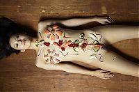 Babes: two asian japanese girls practicing a nyotaimori and serving sushi on a naked woman's body