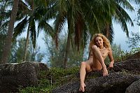 Nake.Me search results: young curly reddish blonde girl strips her pink lingerie on the island with palm trees