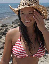 Babes: young black haired girl with a hat undresses her bikini with red and white stripes at the sea