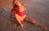 Babes: young blonde girl reveals her red blouse with white dots on the beach at the sea