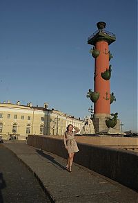 Babes: young brunette girl reveals her coat at the rostral column lighthouse in the city of saint petersburg