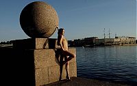 Babes: young brunette girl reveals her coat at the rostral column lighthouse in the city of saint petersburg