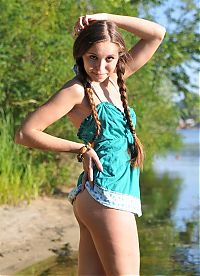 Nake.Me search results: young brunette girl with pigtails undresses her blue chemise on the bank of the river